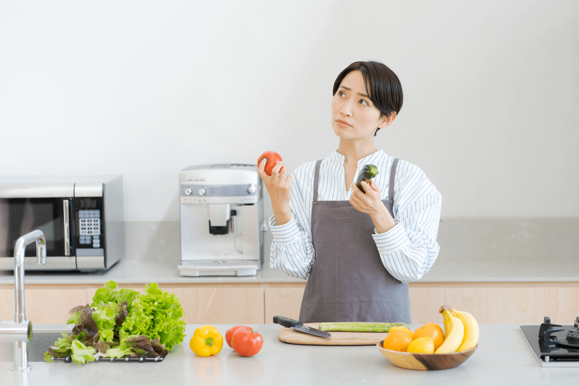 内臓脂肪を減らす食べ物はあるの？野菜を持って悩む女性のイメージ写真