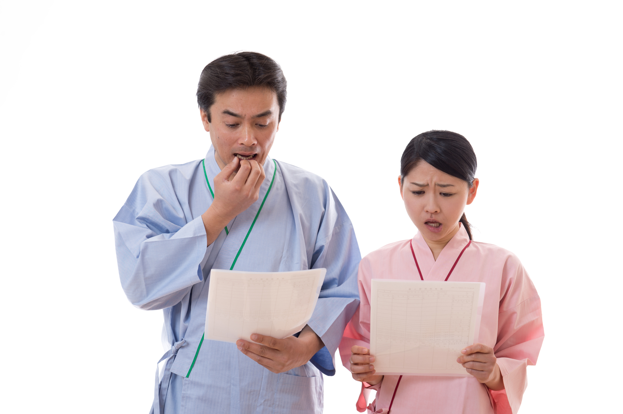 中年の男女が健康診断の結果を見て驚いているイメージ画像