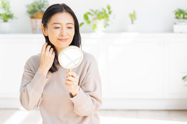 鏡で髪を見ている人の写真