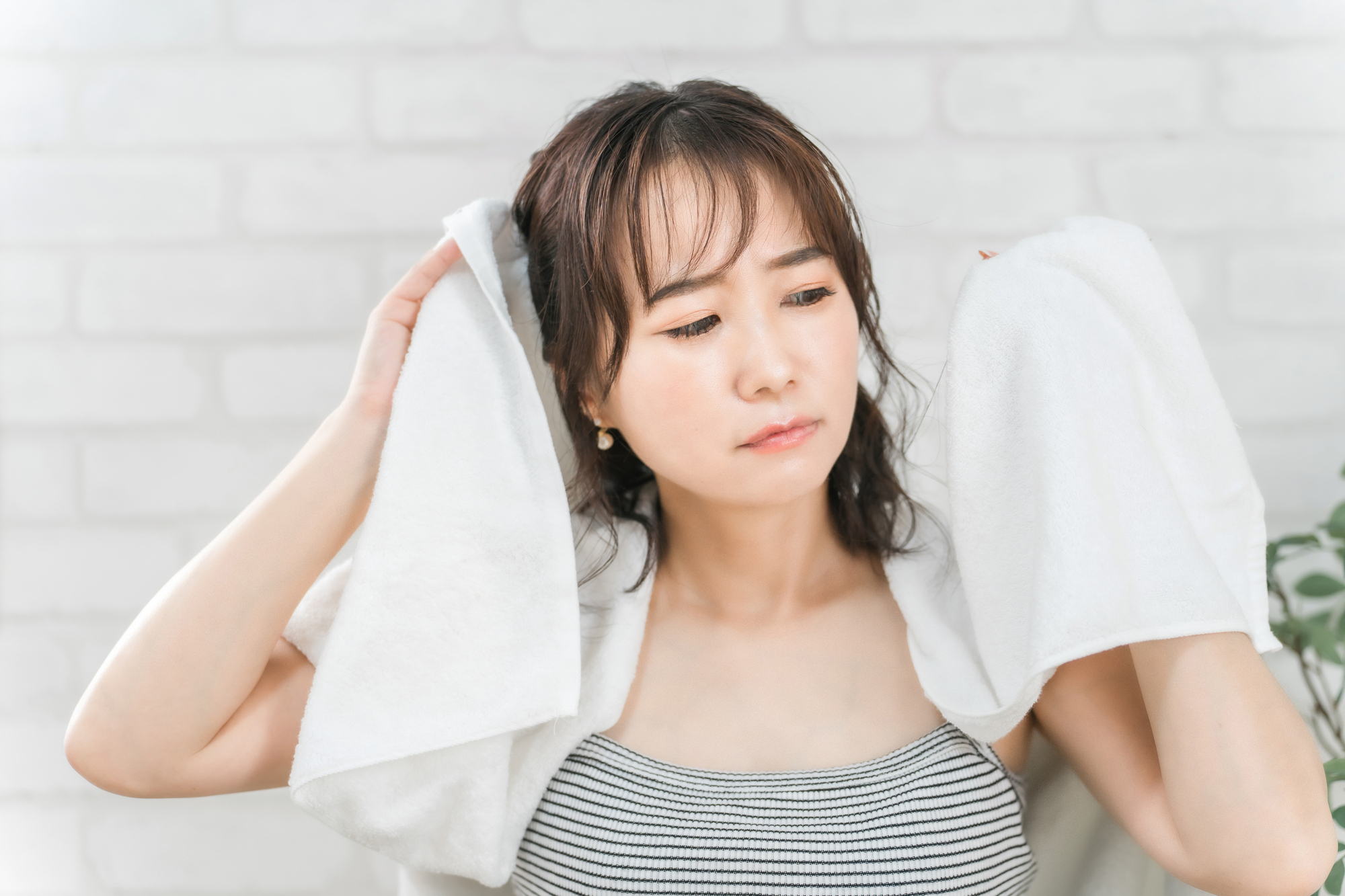 シャンプー後の髪の毛を気にする女性のイメージ画像