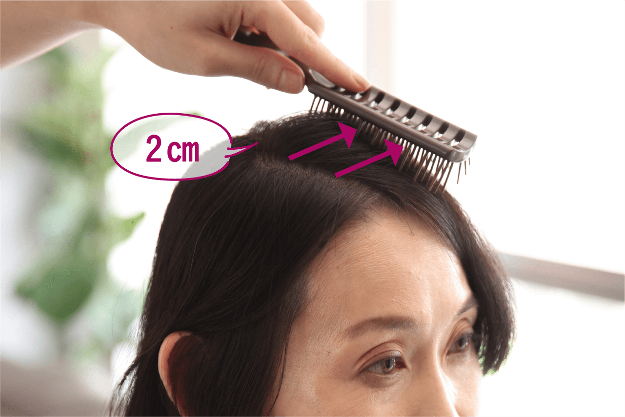 ボリュームを出したい側の分け目に沿ってブラシを軽く置き、そのまま髪をとかすように、ブラシを約2cm滑らせるイメージ画像