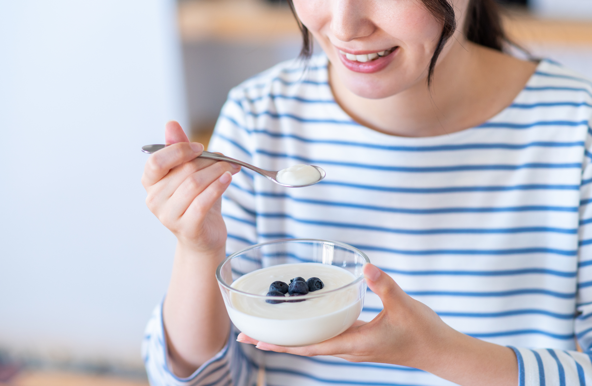 ヨーグルトを食べようとしている女性の写真