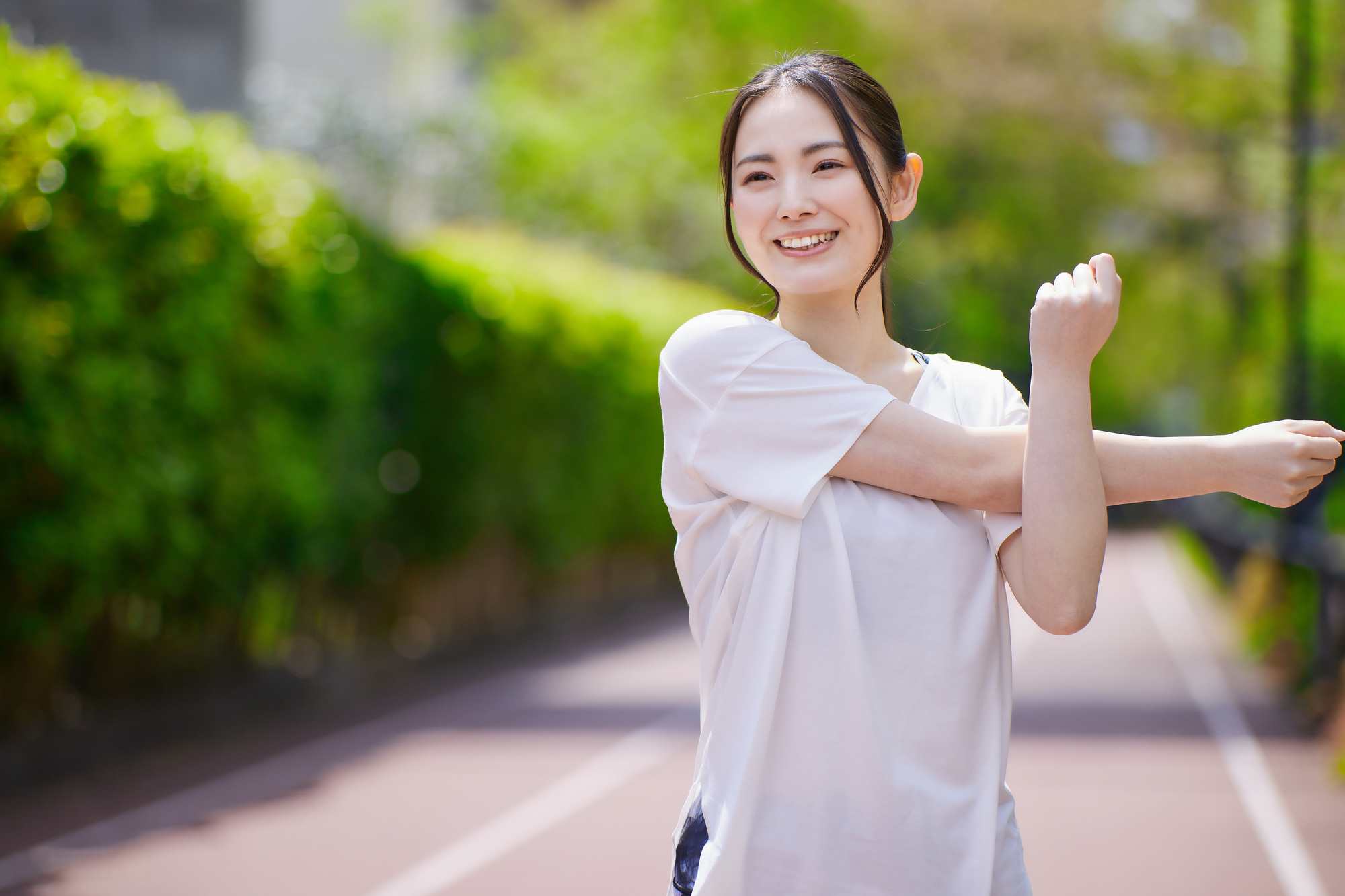 運動前に肩のストレッチをしている女性の写真