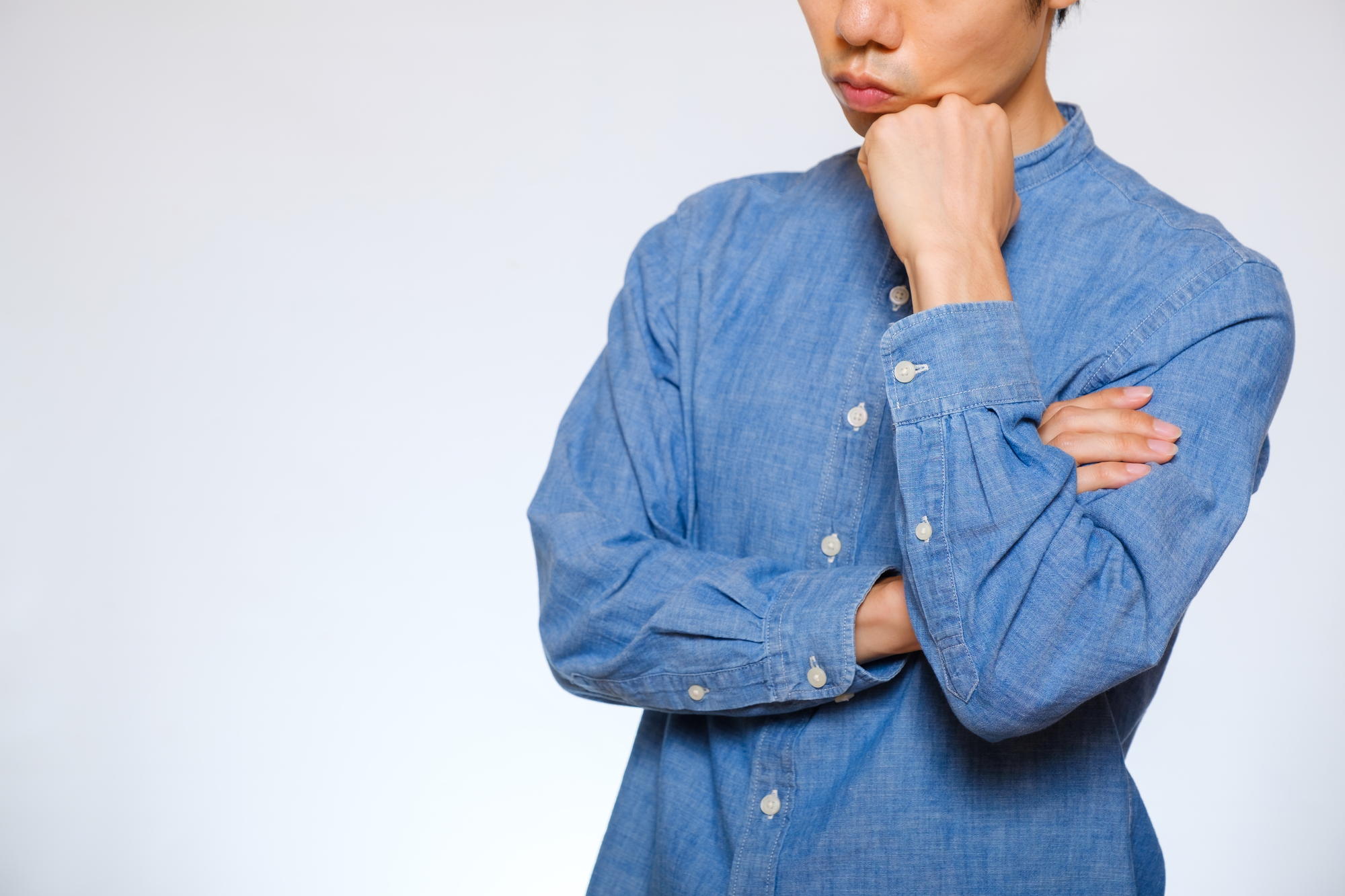 薄毛を自分で改善するには？ 顎に手を当てて悩む男性の写真