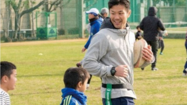 元ラグビー日本代表キャプテンである廣瀬俊朗さんが子供にラグビーを教えている写真